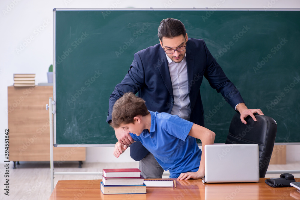 Young male teacher and schoolboy in the classroom Young male teacher and schoolboy in the classroom