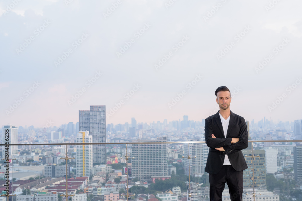 Portrait of businessman standing on the rooftop of a skyscraper with copyspace