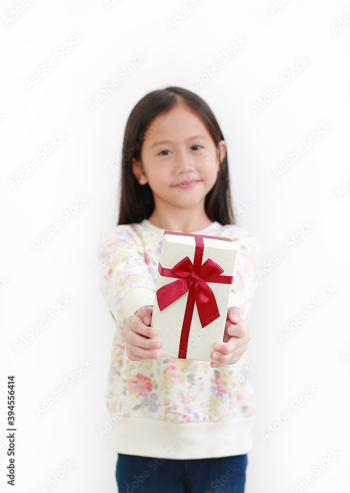 Little asian child girl give you a gift box on white background. Happy new year and Merry christmas concept. Focus at Gift box Little asian child girl give you a gift box on white background. Happy new year and Merry christmas concept. Focus at Gift box