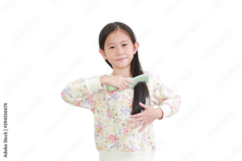 Smiling asian little kid girl combing long hair on white. Hair care concept Smiling asian little kid girl combing long hair on white. Hair care concept