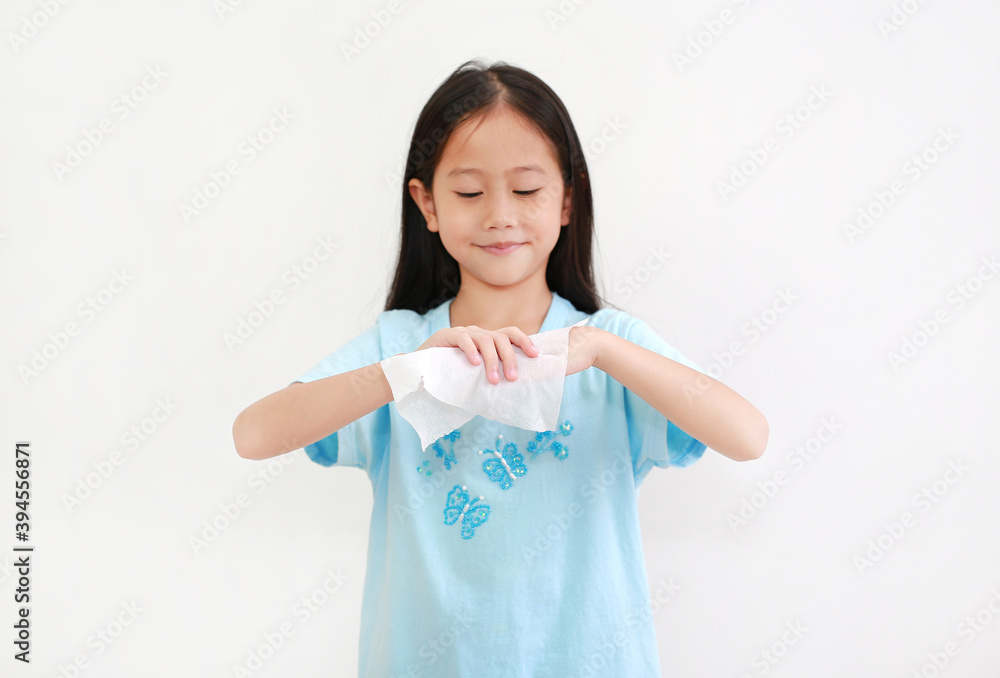 Little asian child girl cleaning hands by wet wipes tissue and alcohol disinfectant on white. Protection coronavirus (Covid-19) infection concept. Focus at kid hands Little asian child girl cleaning hands by wet wipes tissue and alcohol disinfectant on white. Protection coronavirus (Covid-19) infection concept. Focus at kid hands