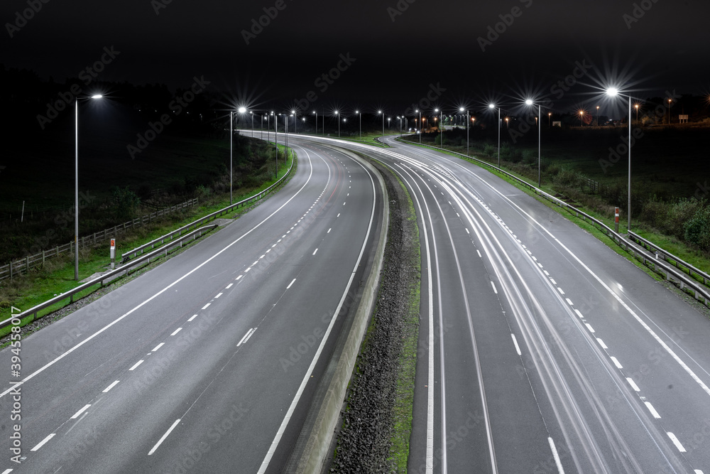 Autostrada nocą z latarniami i samochodami Autostrada nocą z latarniami i samochodami