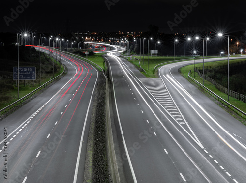 Autostrada nocą z latarniami i samochodami 