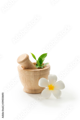 close up view of wooden herbal mortar on white back. 