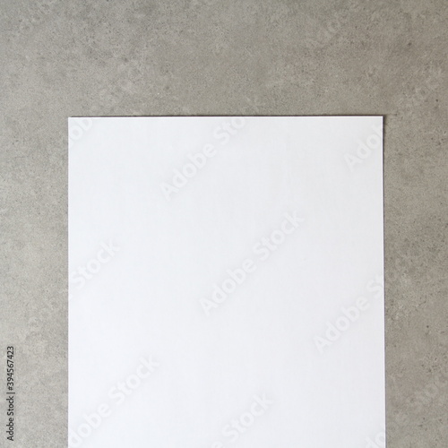 Template of white paper on light grey concrete background. Concept of new idea, business plan and strategy, development and implementation of content. Stock photo with empty space for text