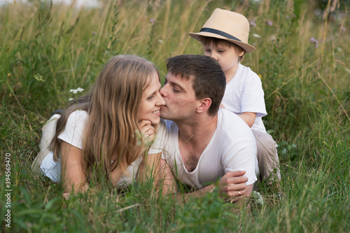 Happy family lying in grass and enjoying walk together at meadow in summer © Elena Odareeva