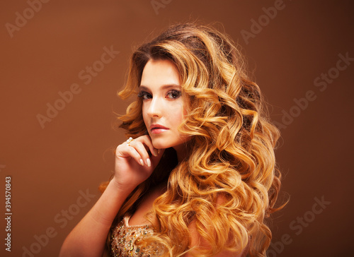 Beaity and fashion concept: Blond woman with long, healthy and shiny curly hair . Beautiful model woman with wavy hairstyle .Care and beauty.
