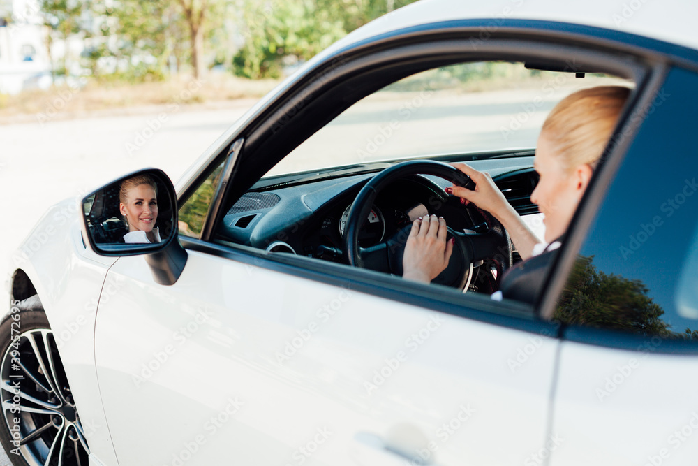 Beautiful female blonde driver behind the wheel of a sports car