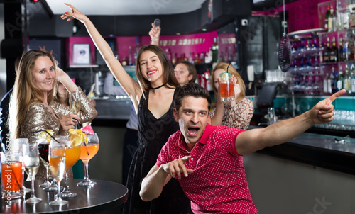 Young students dancing on party with the cocktails at the club
