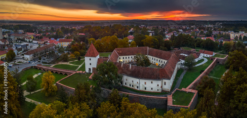 Sarvar, Hungary - Aerial panoramic view of the Castle of Sarvar (Nadasdy castle) with Sarvar Arboretum, a beautiful dramatic sunrise and rain clouds at background on a calm autumn morning photo