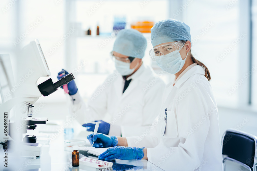 scientists testing the liquid and writing the results in a laboratory journal. scientists testing the liquid and writing the results in a laboratory journal.