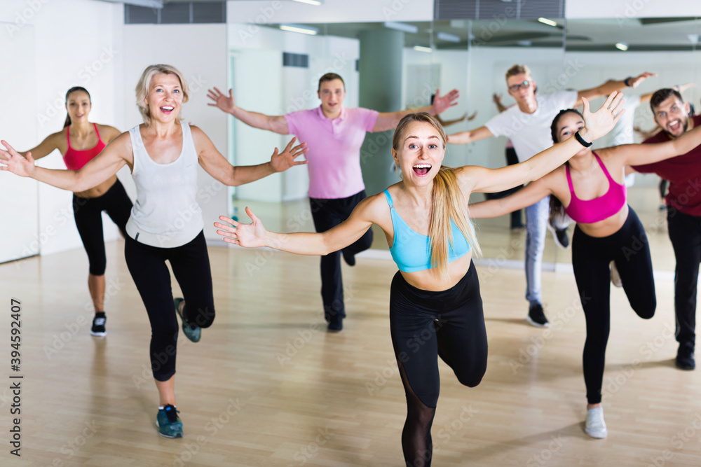 Obraz premium Positive smiling slim athletic women and men dancing strip plastic in class