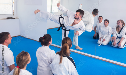 Young male instructor demonstrates his skills in martial arts in the room