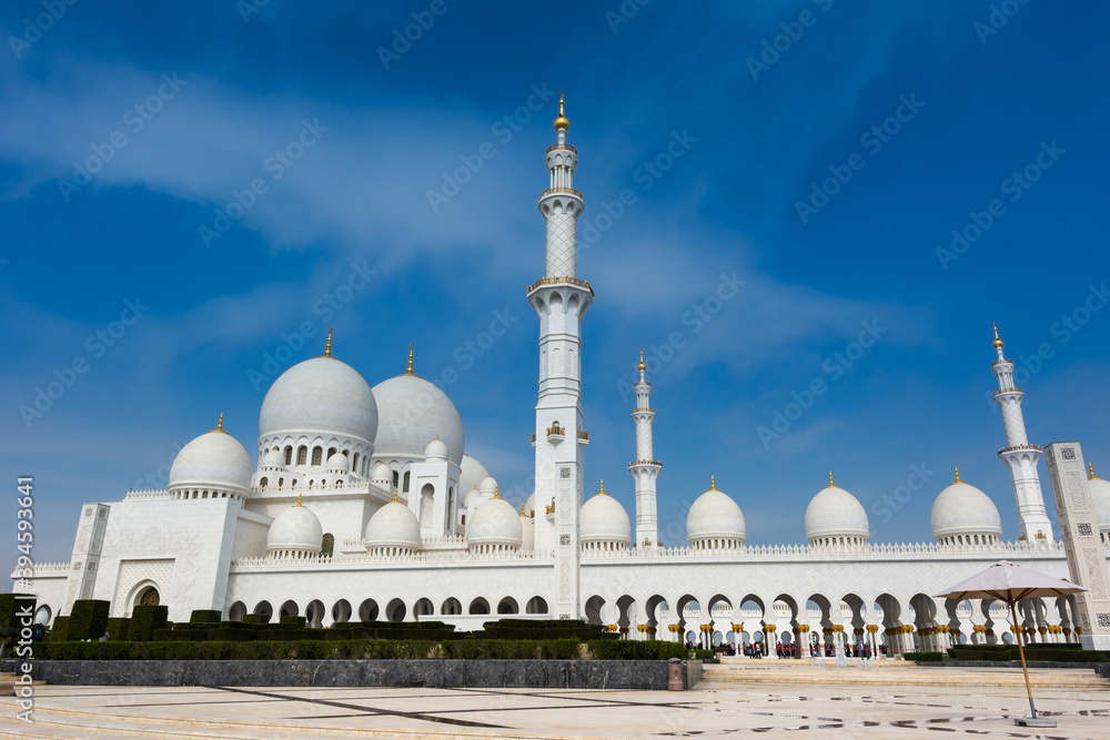 White Grand Mosque built with marble stone against blue sky, also called Sheikh Zayed Grand Mosque in Abu Dhabi, UAE