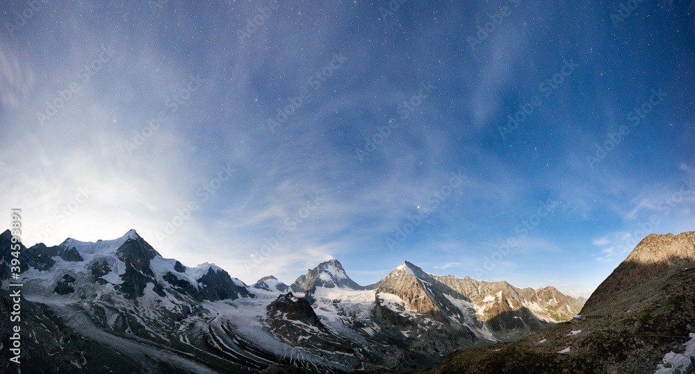 Amazing scenery in evening, beautiful mountains area with white snow. Gorgeous mountain ridge with high rocky peaks Ober Gabelhorn and Dent Blanche with shining stars in sky, wonderland.