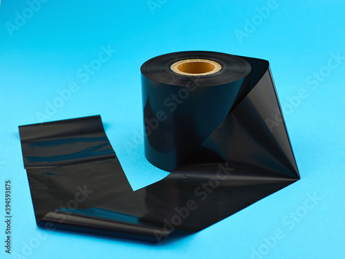 Thermal transfer ribbon. Production of labels using thermal printing technology. Thermal transfer tape on a blue background photo