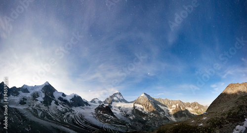 Amazing scenery in evening, beautiful mountains area with white snow. Gorgeous mountain ridge with high rocky peaks Ober Gabelhorn and Dent Blanche with shining stars in sky, wonderland.