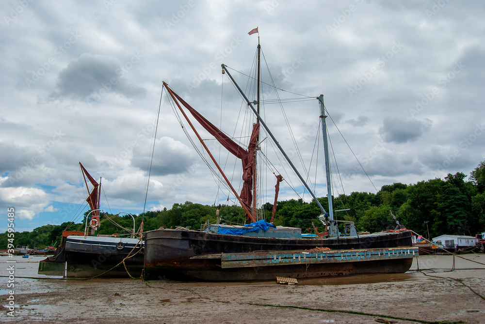 Boats stranded by low tide on the River Orwell at Pin Mill, Suffolk, UK