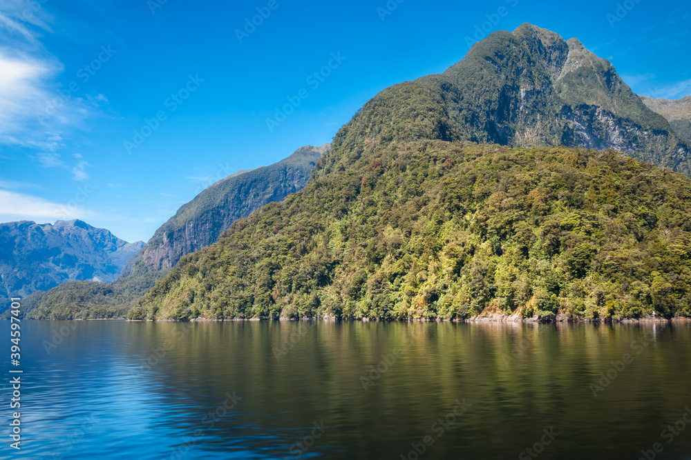 Mountain range spectacular and reflections in the water in the remote wilderness of Deep Cove at Doubtful Sound in New Zealand, South Island. Mountain range spectacular and reflections in the water in the remote wilderness of Deep Cove at Doubtful Sound in New Zealand, South Island.