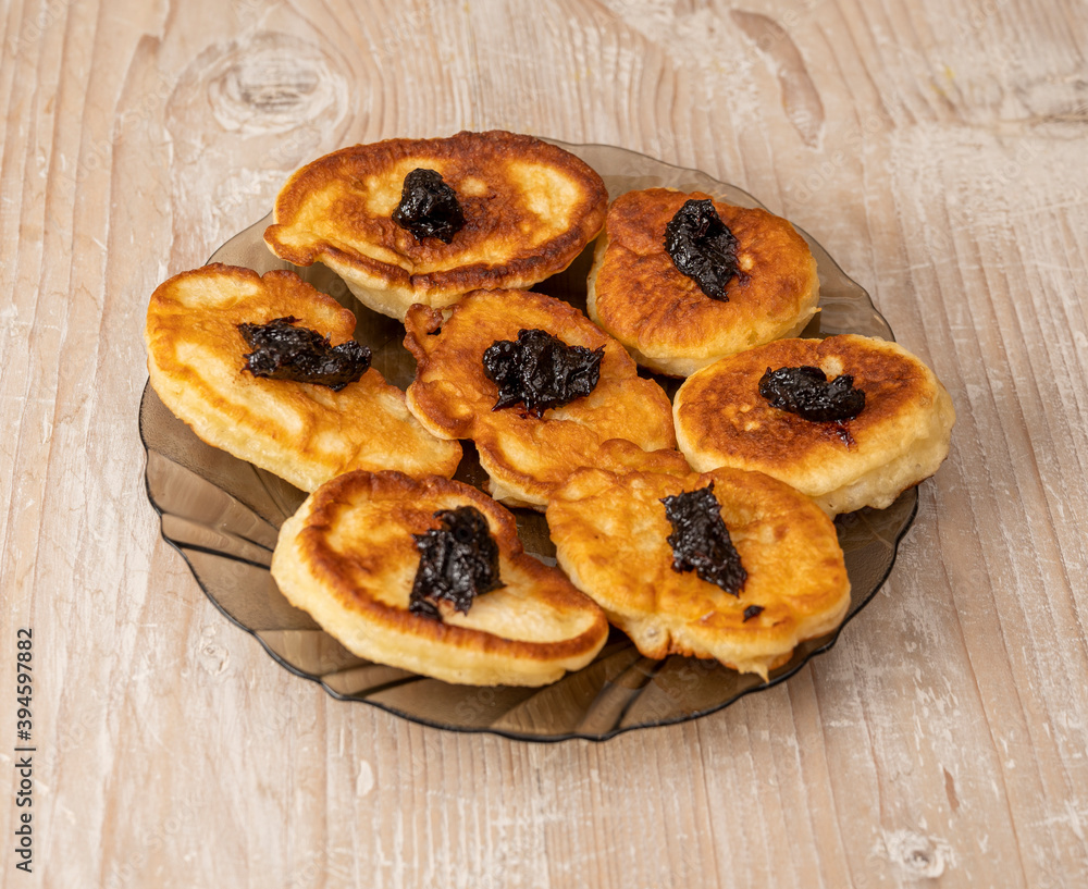 Pancakes or fritters with jam in plate on a table Pancakes or fritters with jam in plate on a table