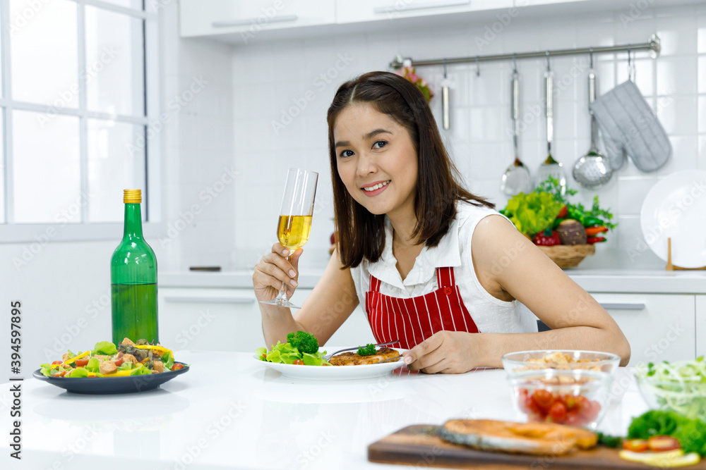 Woman holding glass of champagne in kitchen. Woman holding glass of champagne in kitchen.