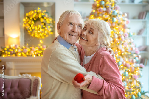 Grey-haired man making a proposal and a happy woman hugging him