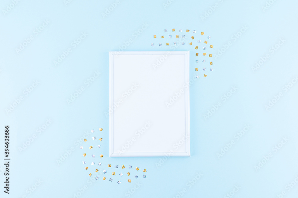 Christmas theme minimalist picture frame. Frame surrounded with Christmas decorations. Flatlay minimal style on blue backdrop. Christmas theme minimalist picture frame. Frame surrounded with Christmas decorations. Flatlay minimal style on blue backdrop.