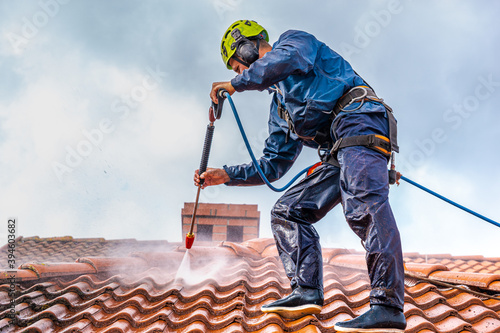 Obraz na płótnie worker washing the roof with pressurized water