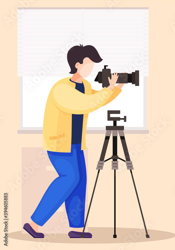 The guy standing and adjusting the lens. Photographic art. A cameraman prepares camera for a photo shoot. Photographer with camera takes picture in the photo studio with the white background
