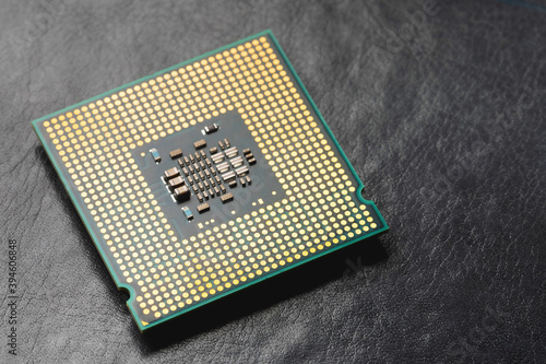 The microprocessor processor of the CPU of a computer or laptop lies on a dark matte surface. Close-up. Electronic and computing equipment. Macro