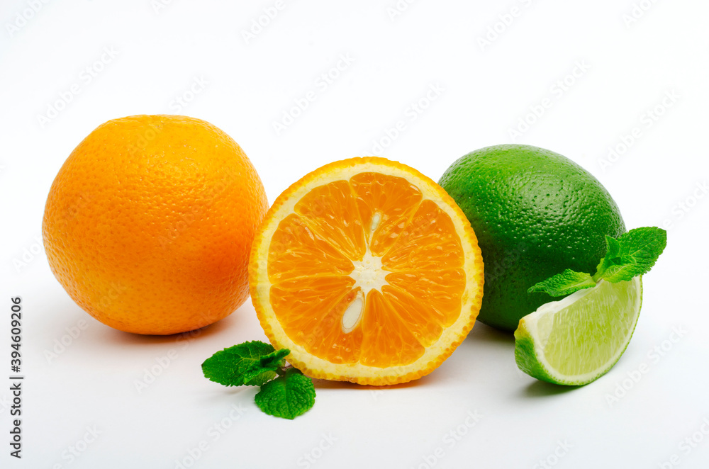 Whole orange, cutted one, lime wedge and whole one, mint leaves on the white background Whole orange, cutted one, lime wedge and whole one, mint leaves on the white background