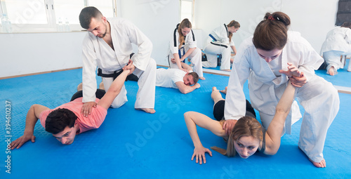 Young american trainees sparring in pairs to practice new holds in taekwondo class