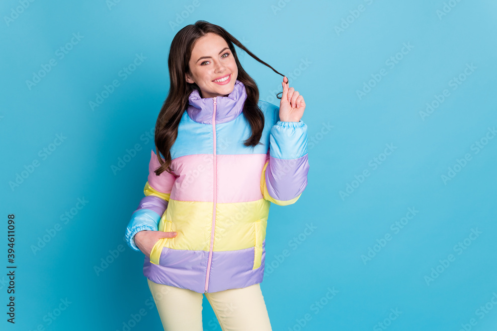 Photo portrait of smiling woman playing with hair isolated on pastel blue colored background with blank space Photo portrait of smiling woman playing with hair isolated on pastel blue colored background with blank space