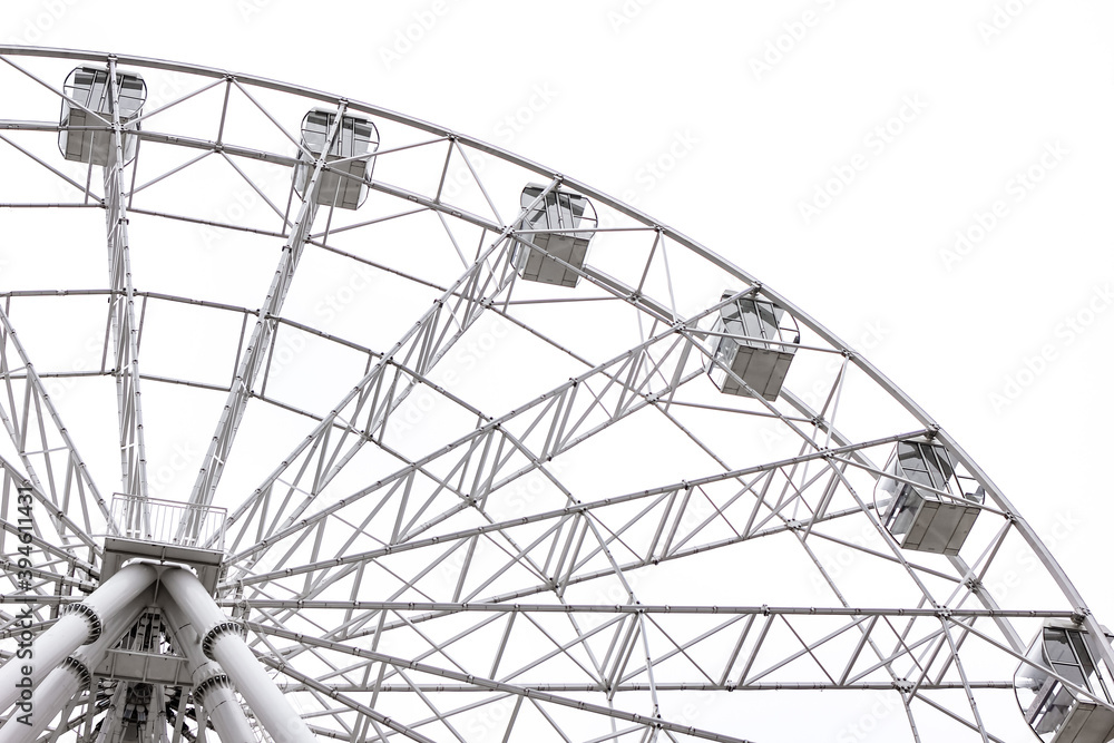 Modern white Ferris wheel in the central park against sky. Entertainment, attraction, amusement park, minimal concept or background. Modern white Ferris wheel in the central park against sky. Entertainment, attraction, amusement park, minimal concept or background.