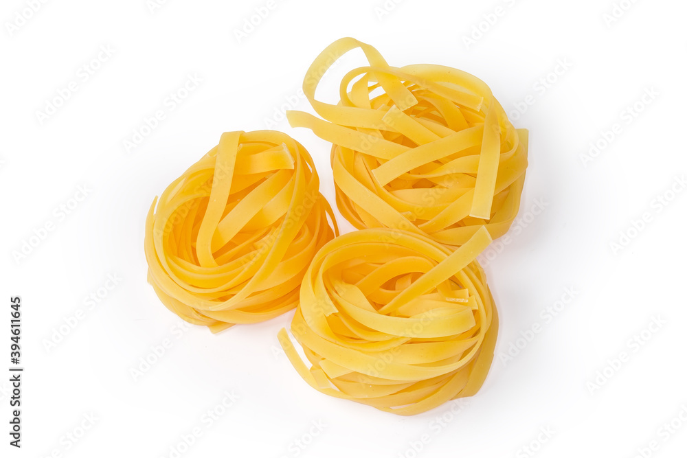 Uncooked noodle coiled into nests on a white background Uncooked noodle coiled into nests on a white background