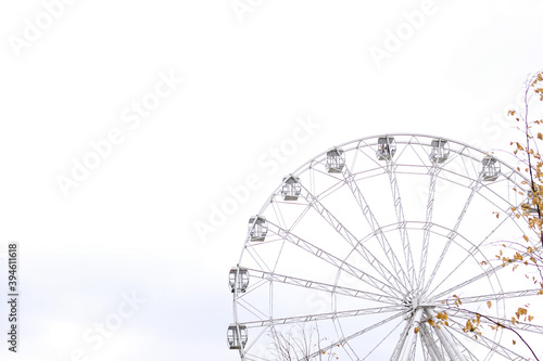 Modern white Ferris wheel in the central park against sky. Entertainment, attraction, amusement park, minimal concept or background.