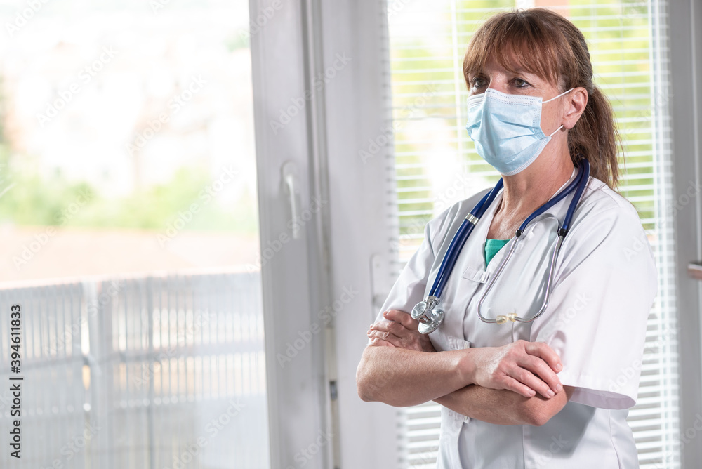 Female doctor with arms crossed wearing a face mask Female doctor with arms crossed wearing a face mask
