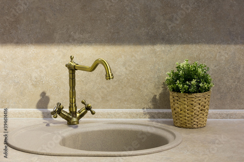 round porcelain tile kitchen sink on the kitchen countertop and retro brass faucet