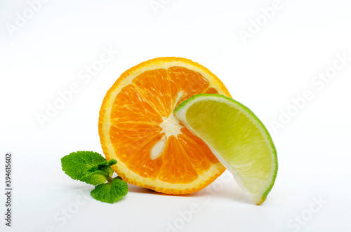 Closeup of slice of lime and cutted orange  green fresh mint on the white background