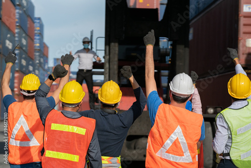 Group of people worker protesting in factory . Male group of protestors fists raised up in the air. Logistics and transportation business Containers import export concept .