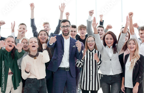 happy group of young employees with hands up