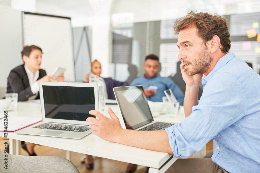 Business Mann am Laptop telefoniert mit dem Handy Business Mann am Laptop telefoniert mit dem Handy