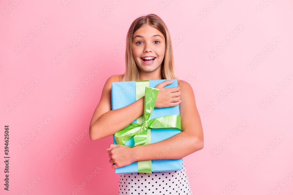 Photo of optimistic blond girl hug present wear white dress isolated on pastel pink color background Photo of optimistic blond girl hug present wear white dress isolated on pastel pink color background