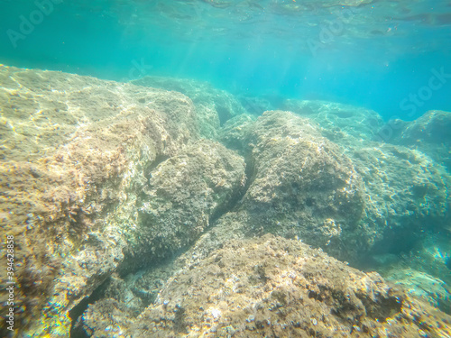 Turquoise water and rocks in Alghero shore seen from underwater
