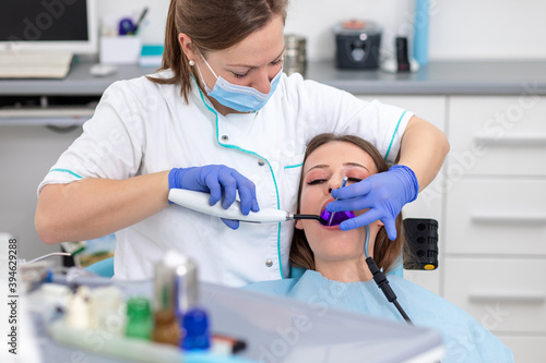 Young woman having teeth examined by female dentist in dental office.