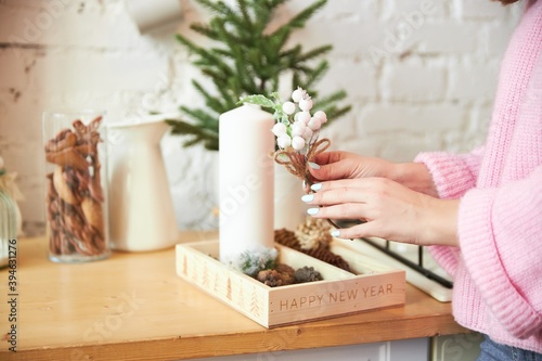 A woman makes Christmas decor in a light loft room