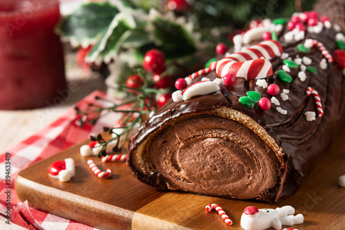 Chocolate yule log christmas cake on wooden table 