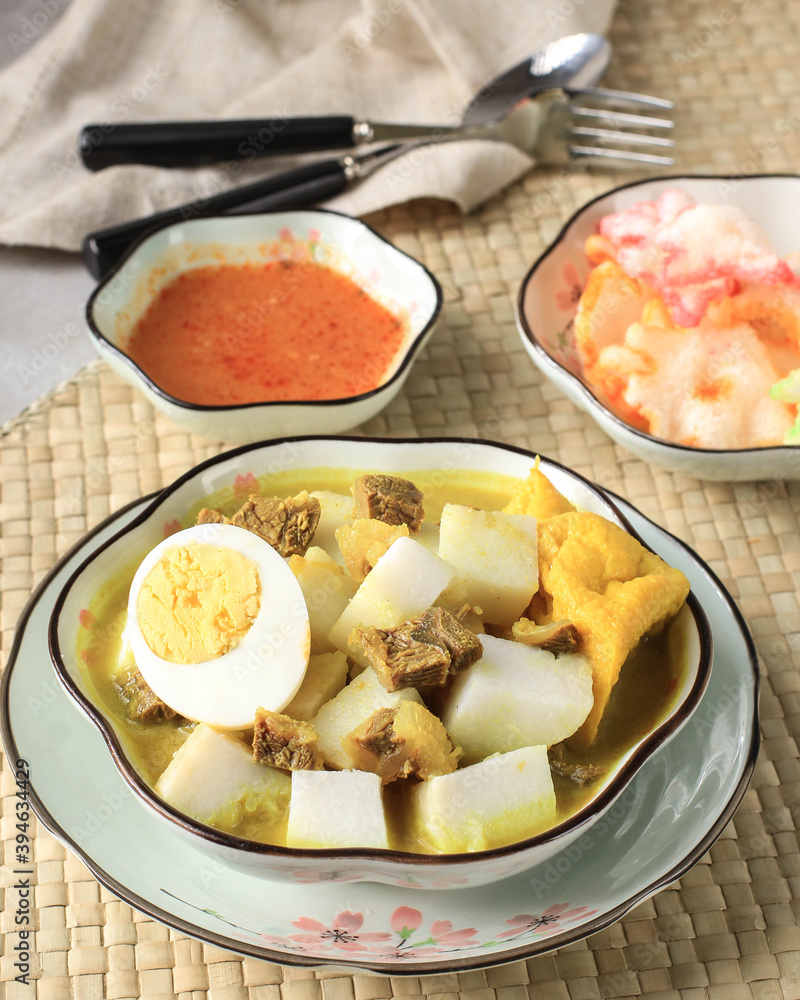Indonesian Traditional Cuisine: Lontong Kari Sapi, Rice Cake or Ketupat Served with Beef Curry Soup Made from Beef Stock and Light Coconut Milk, Various Spice and Indonesian Herbs