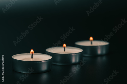 Small glowing candles on a black background