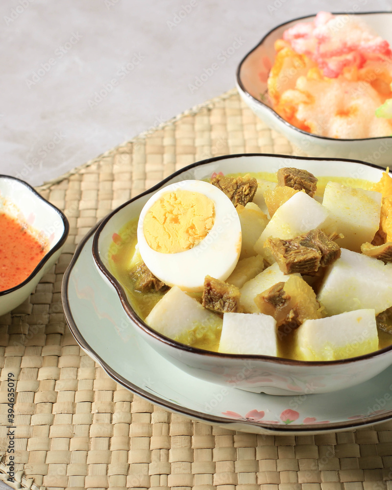 Indonesian Traditional Cuisine: Lontong Kari Sapi, Rice Cake or Ketupat Served with Beef Curry Soup Made from Beef Stock and Light Coconut Milk, Various Spice and Indonesian Herbs Indonesian Traditional Cuisine: Lontong Kari Sapi, Rice Cake or Ketupat Served with Beef Curry Soup Made from Beef Stock and Light Coconut Milk, Various Spice and Indonesian Herbs